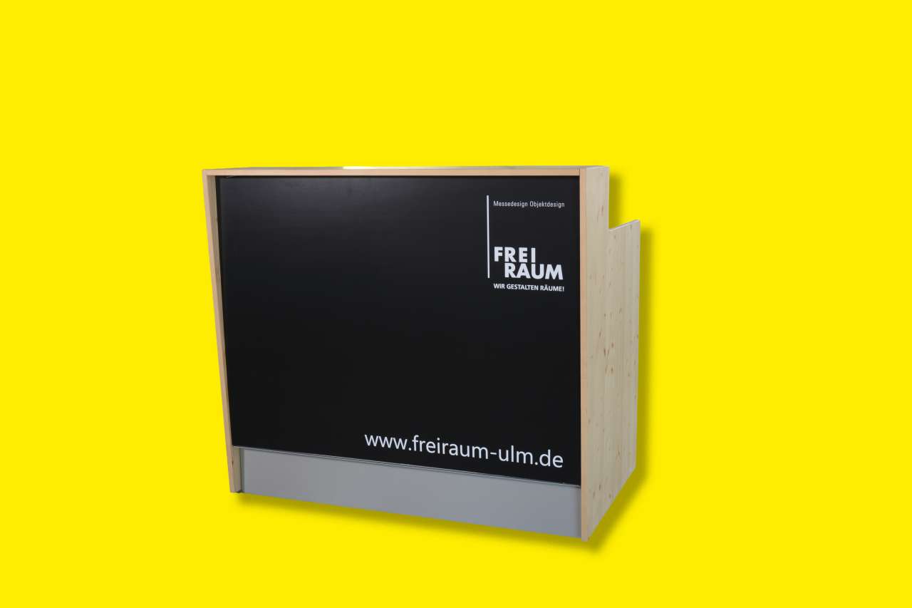 Freiraum Theke Fichtenholz und schwarzer Front mit Logo vor gelbem Hintergrund.